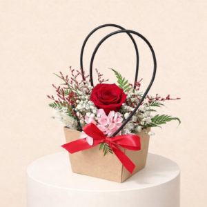 A chic bag filled with a blend of red and yellow baby roses, accented with a few delicate roses, and paired with a vibrant red heart-shaped foil balloon.